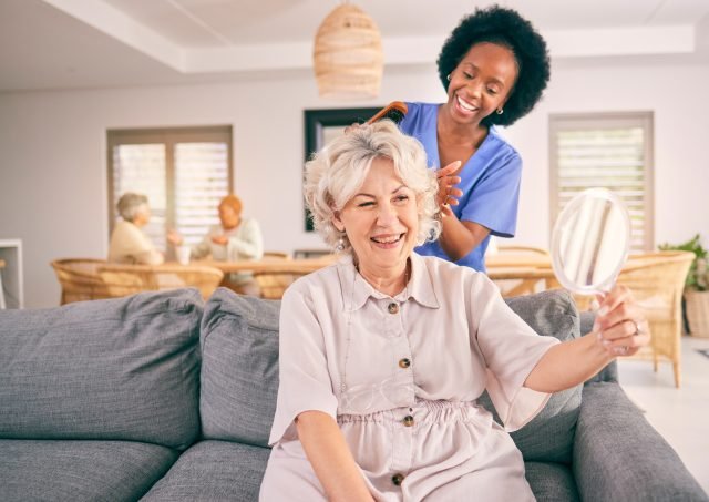 caregiver brushing senior woman's hair